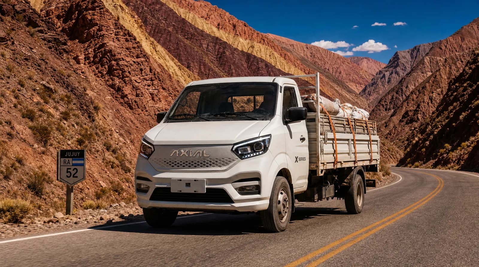 Camión liviano AXIAL X Series blanco sobre ruta de montaña